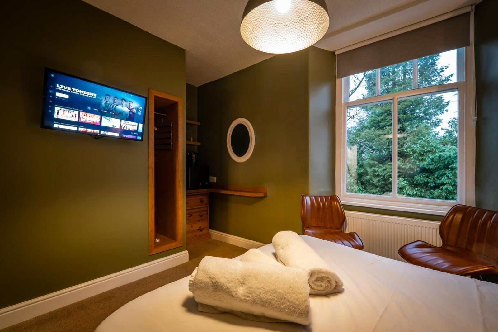 Guest room with leather chairs and television at Glen Wynne Guest House
